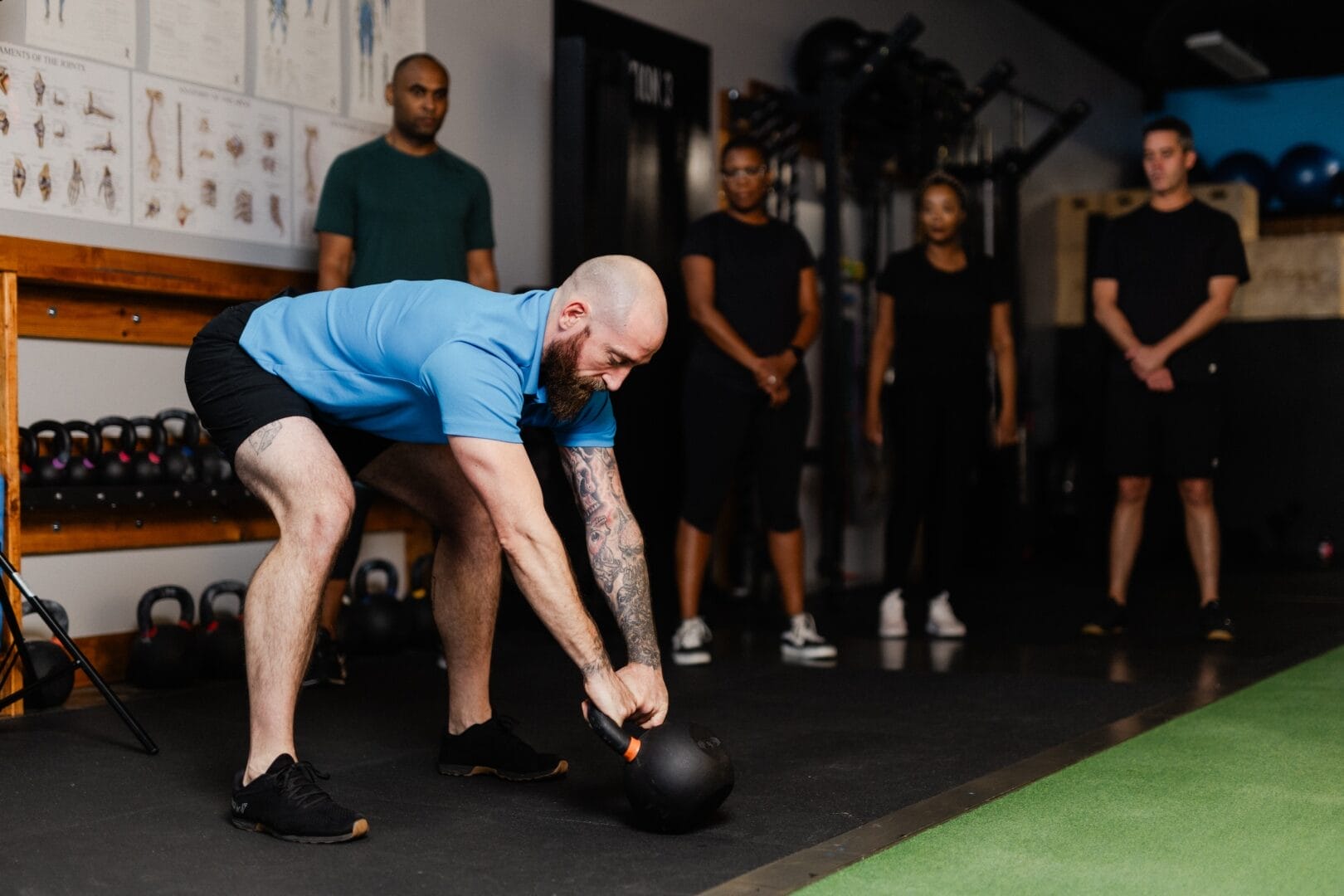 Coach performing kettlebell lifting at Max-imum Fitness and Health